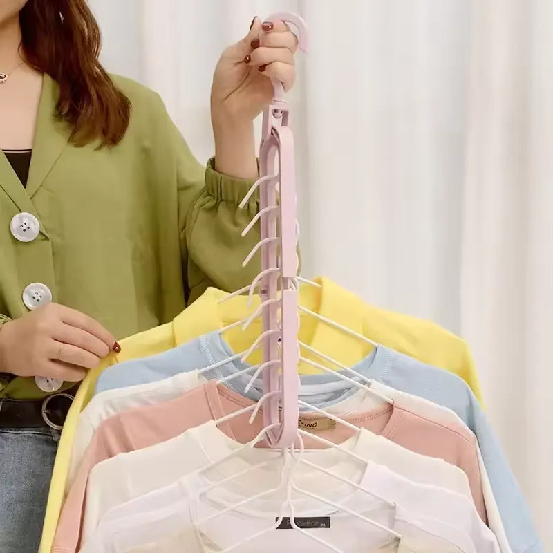 Woman holding a pink Smart Hanger Pro™ vertically, displaying multiple colorful t-shirts neatly organized and saving closet space.